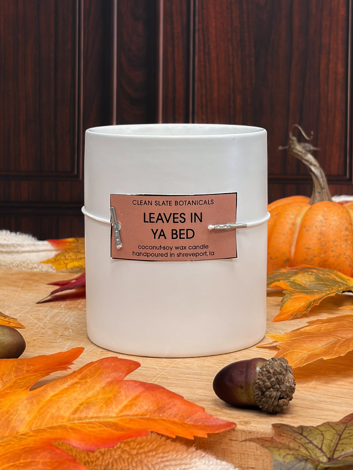 Leaves In Ya Bed Candle in a white glass jar with a copper label and autumn leaf design