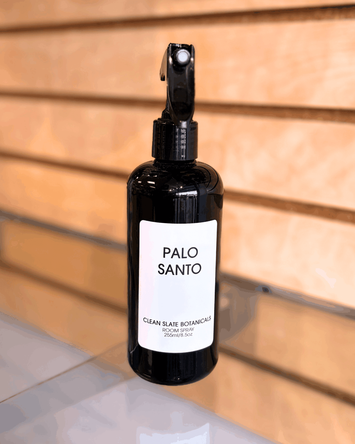 Palo Santo Room Spray in a black plastic spray bottle with white label featuring simple black text
