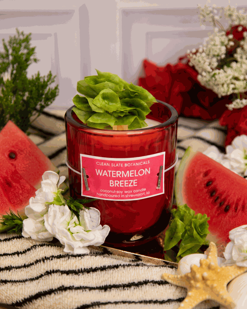 Watermelon Breeze Candle in a translucent ruby-red glass vessel with a pink label and green succulent-shaped wax decoration